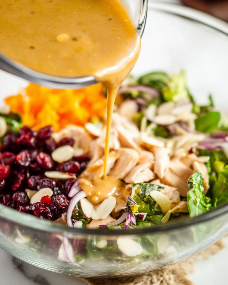 Plated cranberry chicken salad dish with homemade Asian dressing drizzled on top.