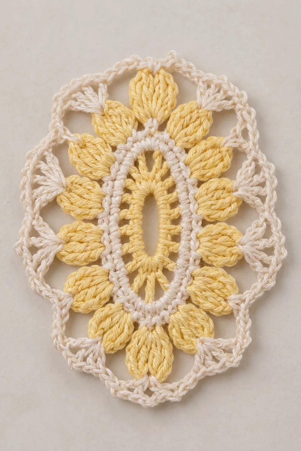 Crocheted lace doily with golden-yellow flower motif and cream openwork border on beige background.