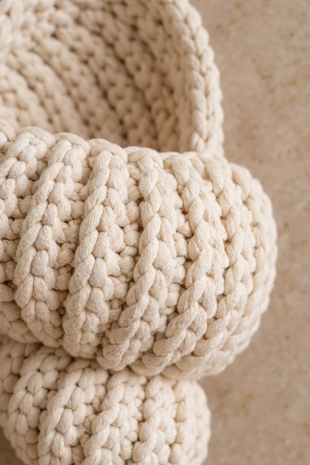 Close-up detail of cream-colored twisted rope showcasing intricate braided texture against a neutral backdrop.