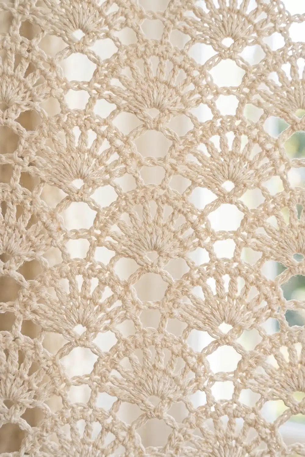 Cream crochet lace with repeating petal starburst motifs and geometric open squares.