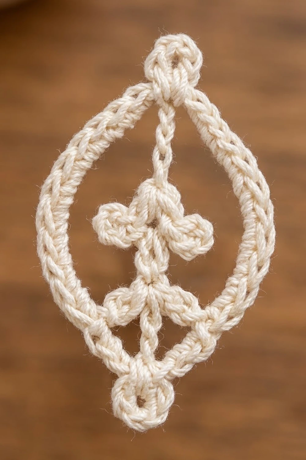 Cream twisted rope with knotted details against a warm, blurred brown background.