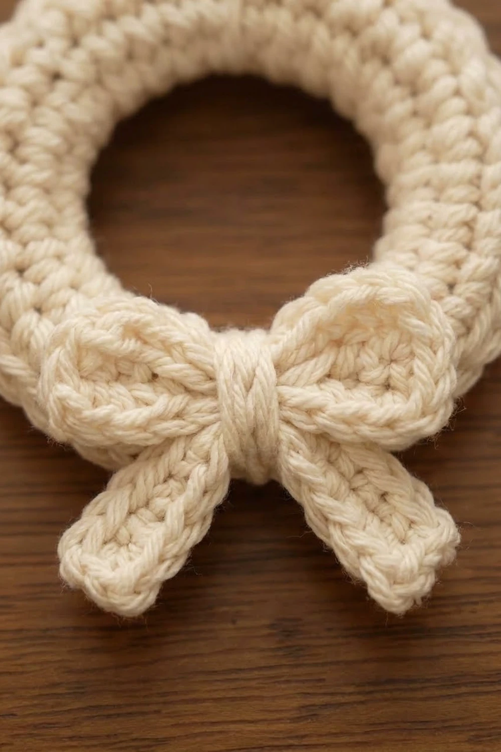 Close-up of a natural cotton rope toy with a knotted bow design on a wooden surface.