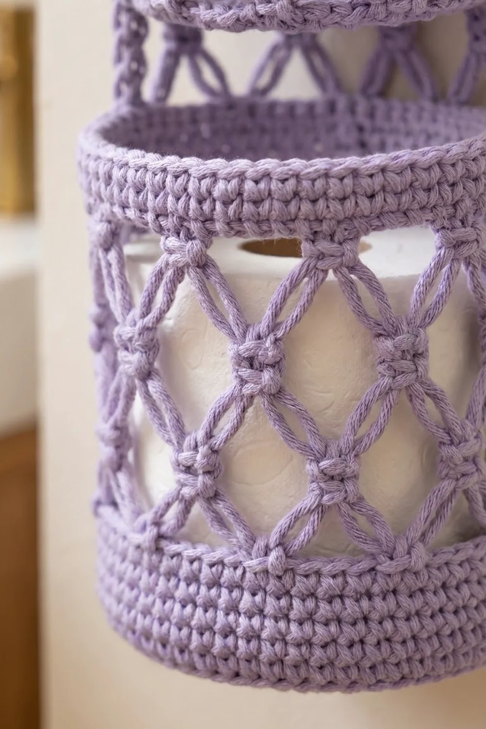 Lavender crocheted basket with textured ribbed bands and decorative looped diamond pattern detail.