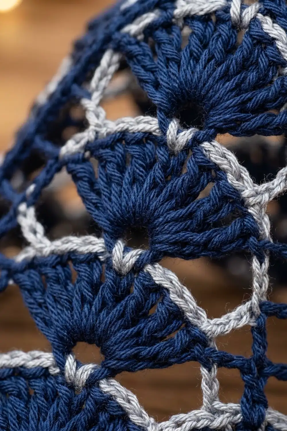 Close-up of twisted blue and white rope netting with detailed knots against a blurred tan background.