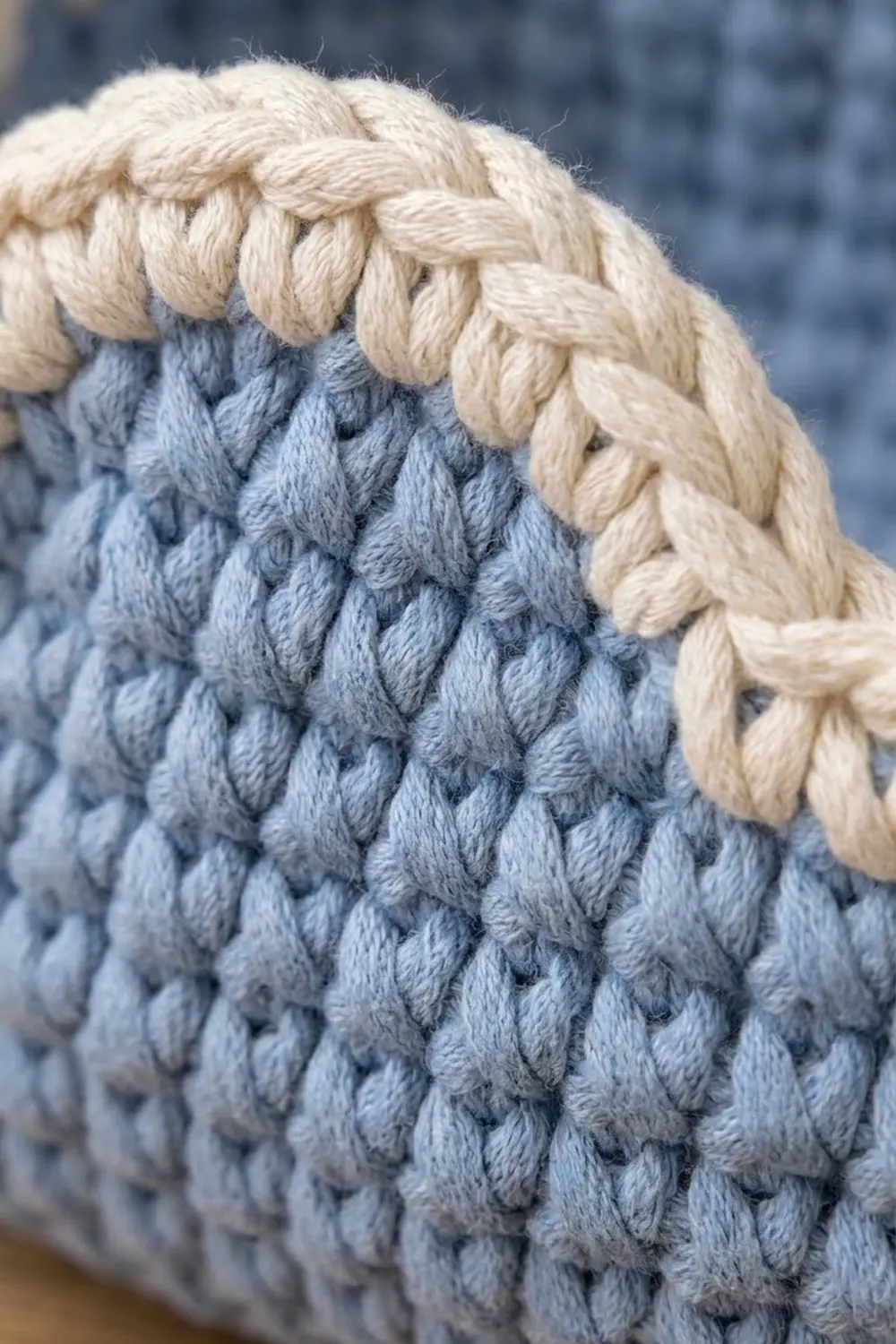 Cream braided trim crowns blue crochet with intricate cable pattern and textured stitching.