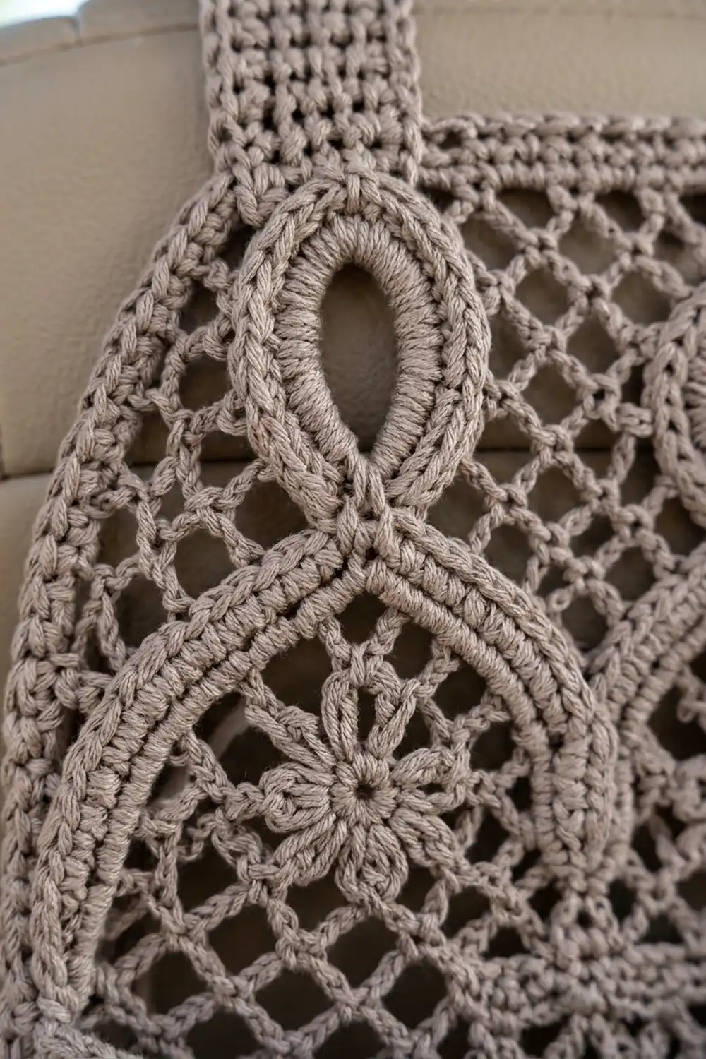 Cream-colored crochet showing delicate openwork with diamond and oval motifs in a lacy pattern.