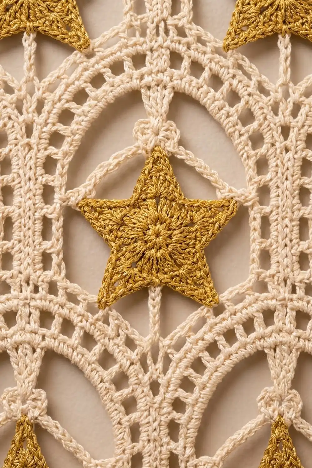 Gold crochet star centered in a cream-colored geometric lace pattern with detailed stitch texture.
