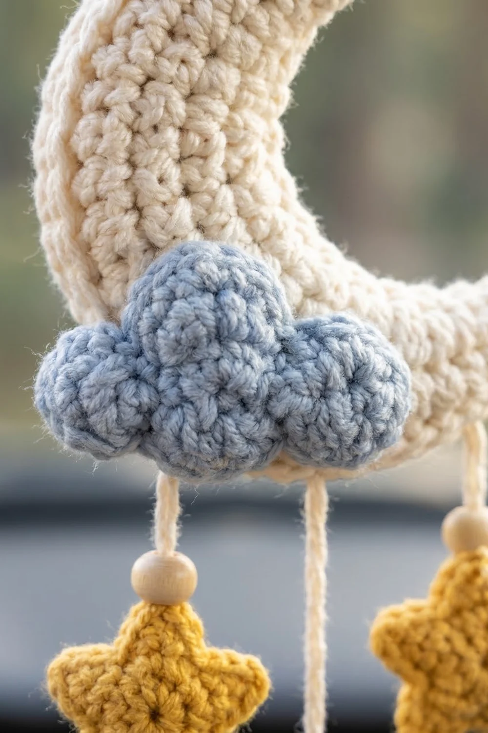 Handmade crocheted amigurumi with a textured blue pom-pom head, cream torso, and yellow feet accented with white beads.