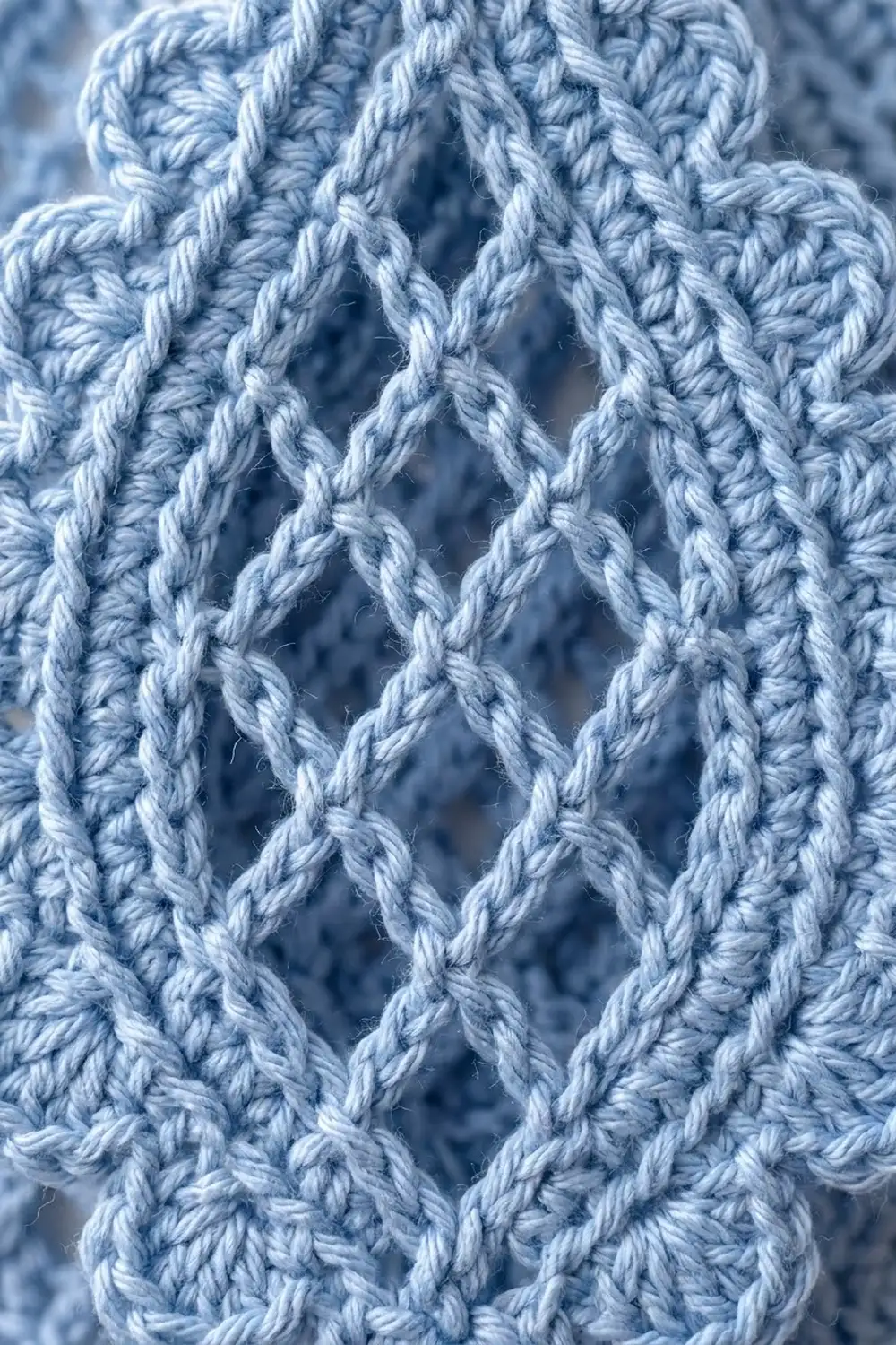 Frost-covered white rope with twisted strands creating a diamond lattice pattern against a blurred blue background.