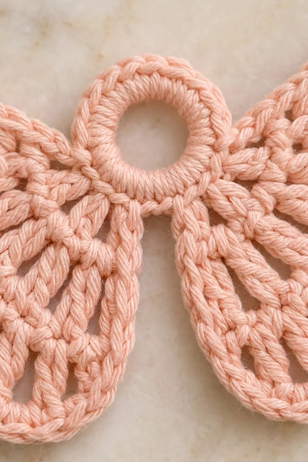 Close-up of intricately braided pink rope forming decorative loops against a neutral beige background.