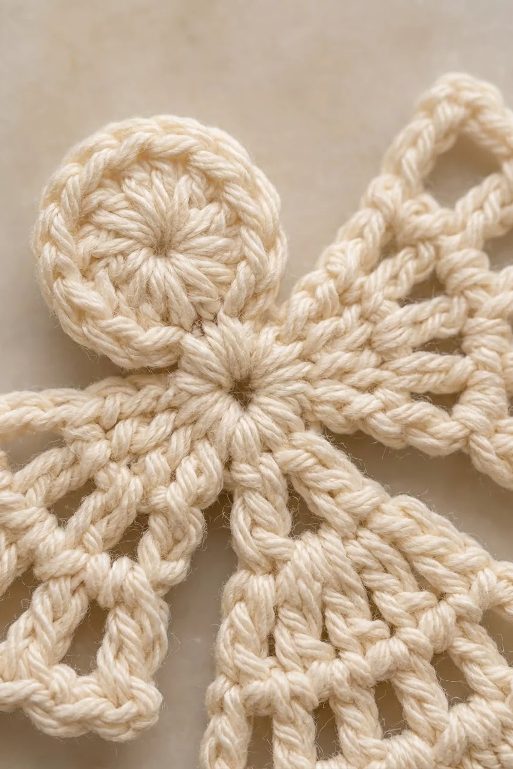 Close-up of a cream-colored crocheted octopus toy showing detailed twisted rope texture and stitching.