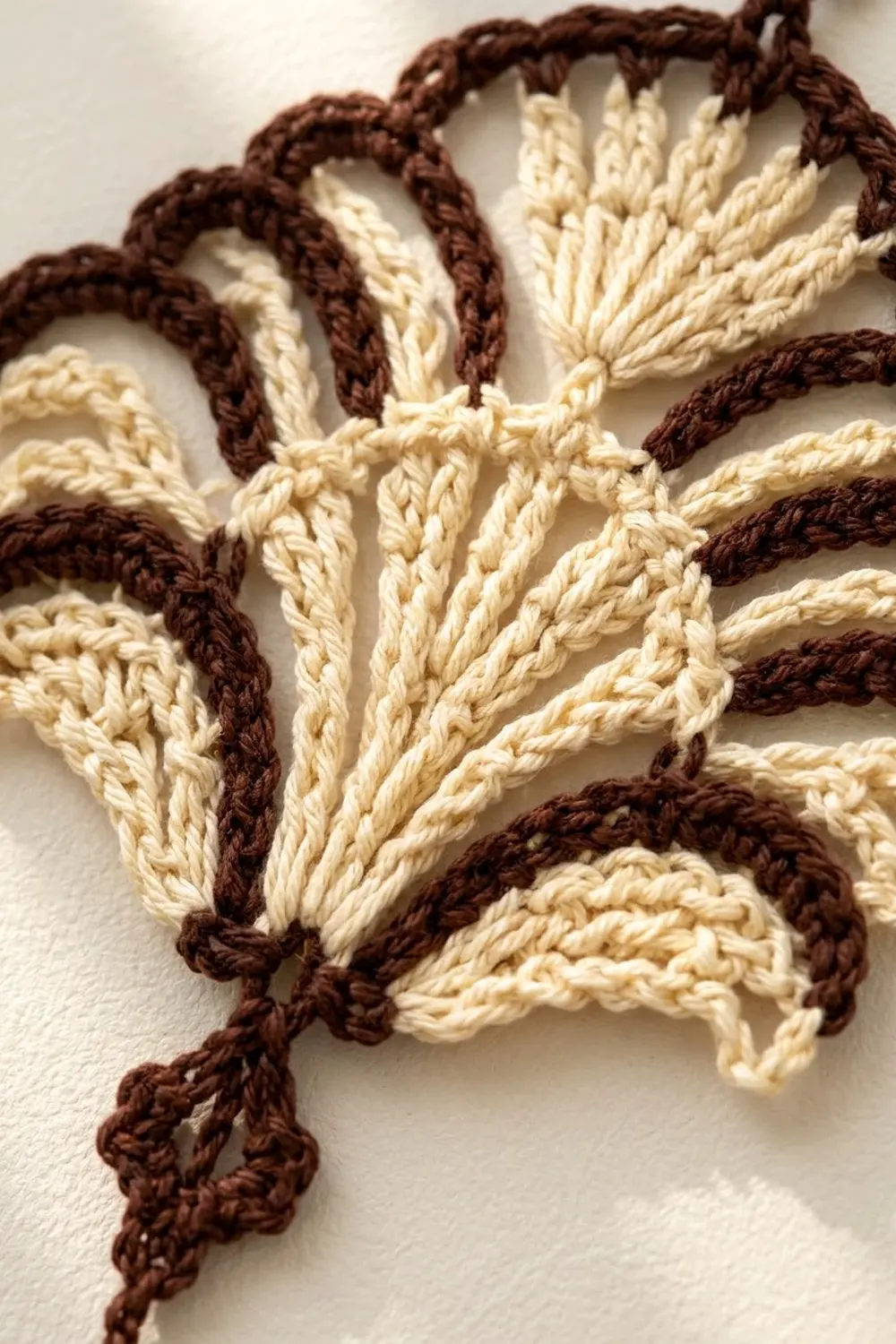 Twisted rope in cream and brown colors arranged in a decorative pattern on white background.