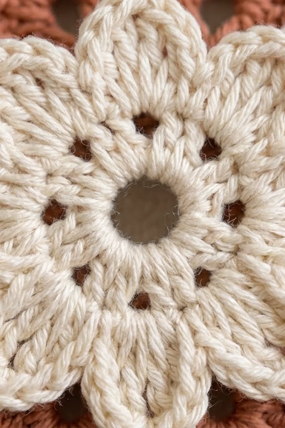 Close-up of cream-colored twisted rope with knots forming a decorative pattern against a brown background.