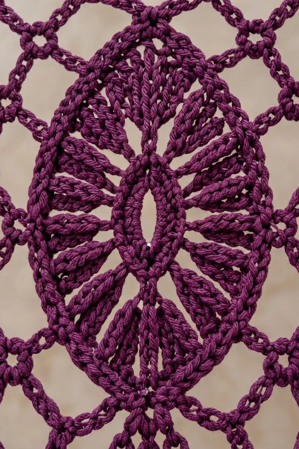 Deep purple macramé with interlocking diamond patterns in twisted rope on neutral background.