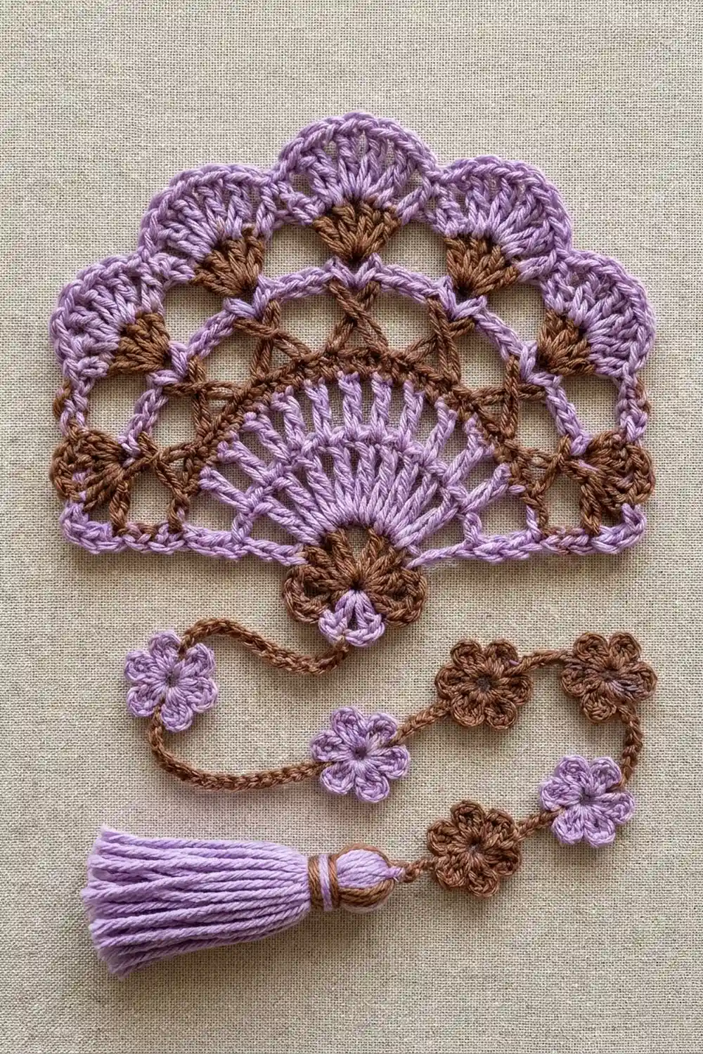 Delicate crochet flowers in lavender and brown with matching tassel detail on light linen.