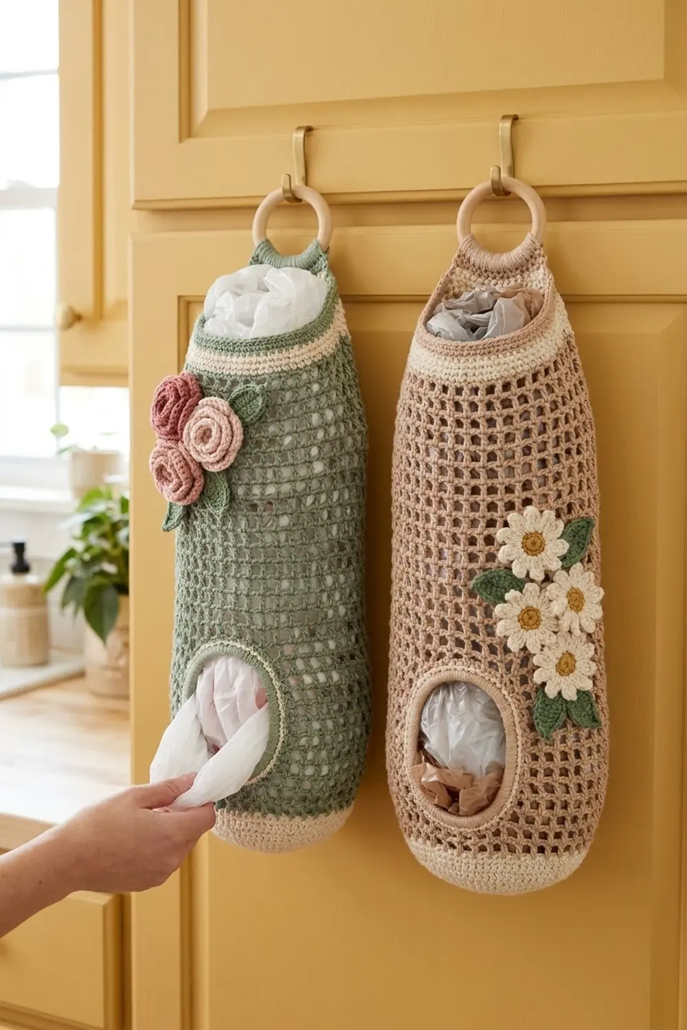 Crocheted tissue organizers in sage green and beige with decorative flowers, hanging from a yellow paneled door.