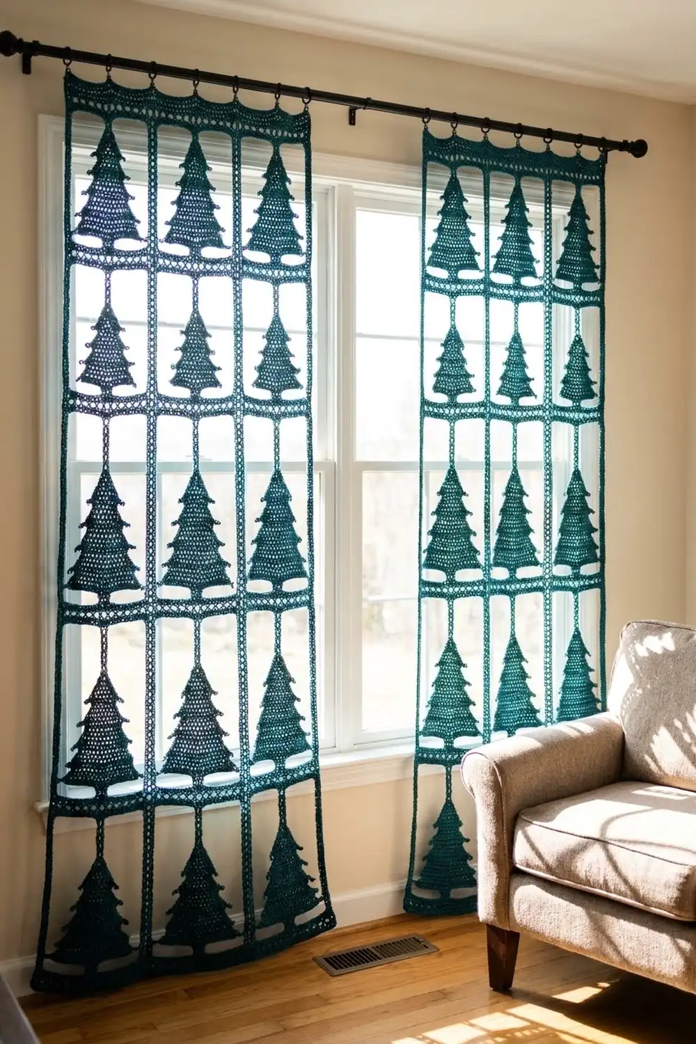 Dark teal crocheted curtains with Christmas tree motifs hang on a black rod in front of bright windows.