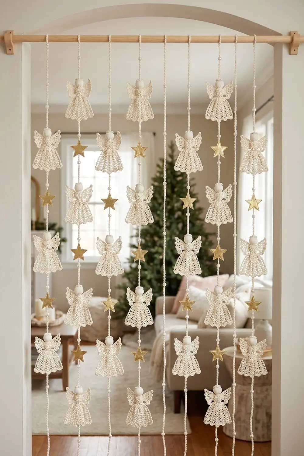 Handmade cream lace angels and gold stars on twine hang from a wooden rod in a sunlit window.