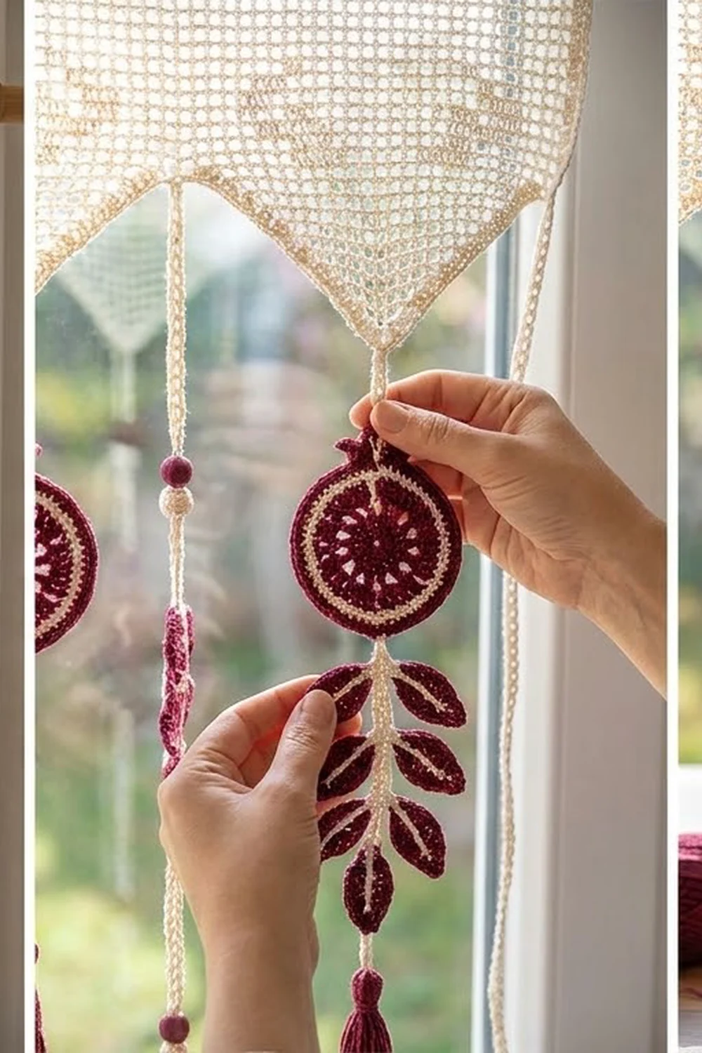 Burgundy crocheted ornaments with cream lace banner hang decoratively at a bright sunny window.