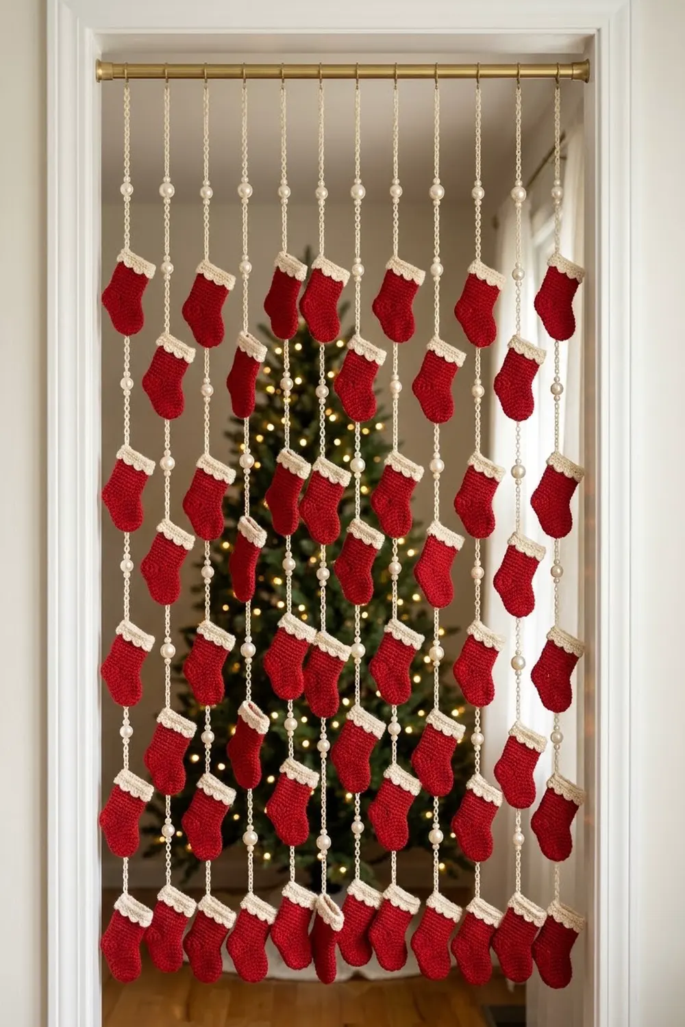 A red and cream knit stocking advent calendar hanging in a doorway with a decorated Christmas tree visible behind it.