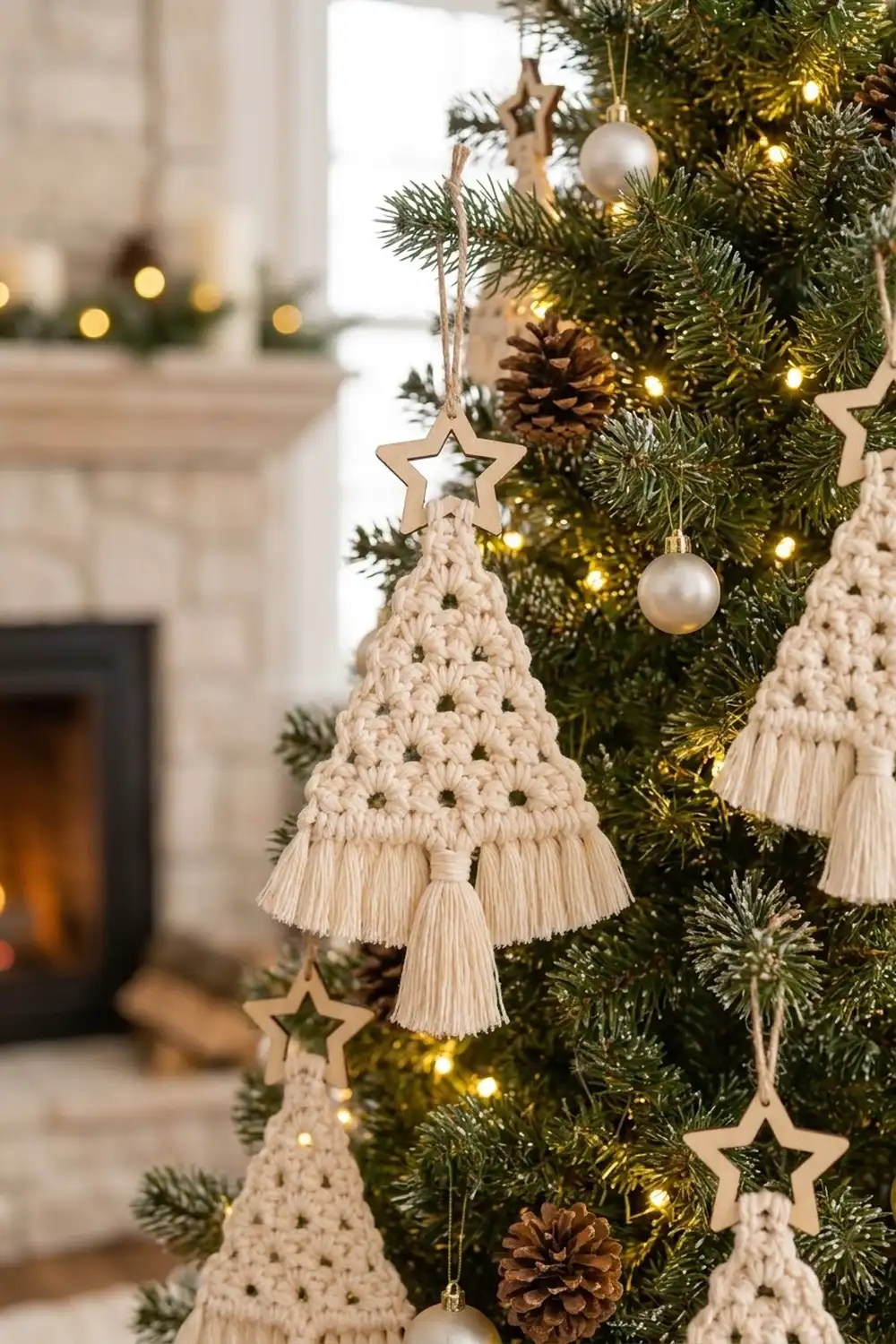 Cream macramé tree ornaments with fringe hang from a decorated Christmas tree beside wooden stars and silver baubles.