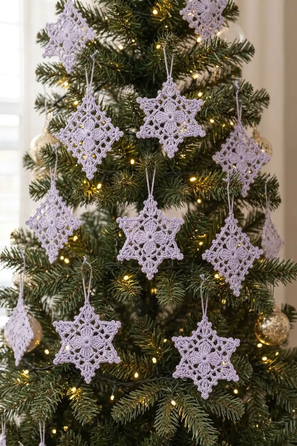 Lavender crochet snowflake and diamond ornaments hanging on an evergreen Christmas tree with warm lights.