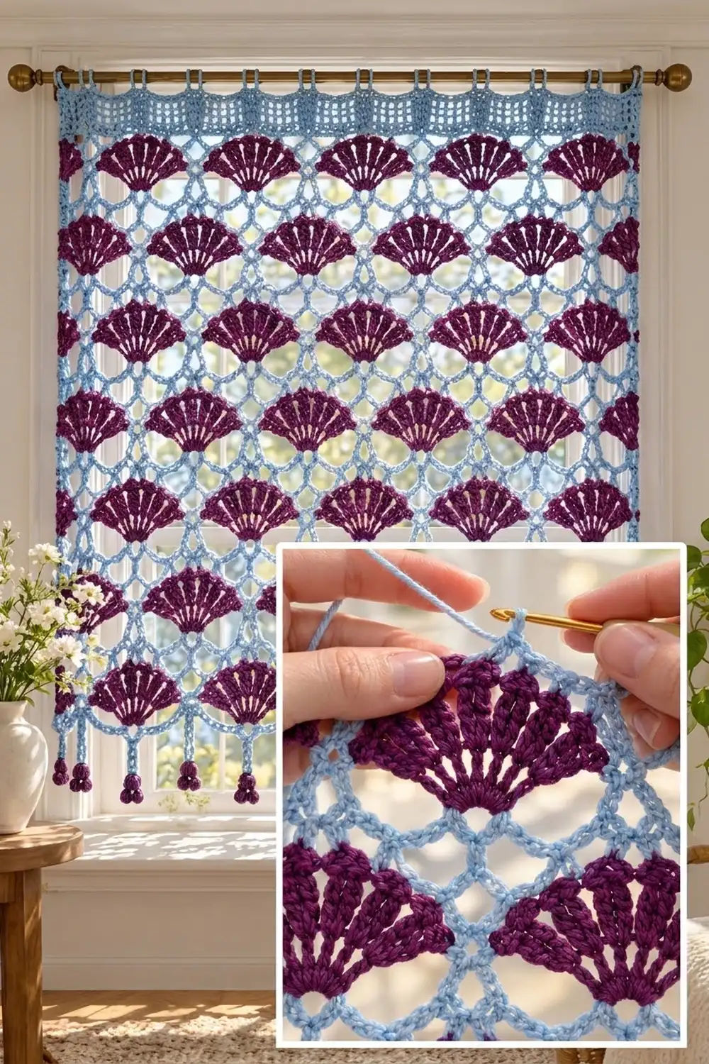 Burgundy and light blue crocheted curtain with shell motifs hanging at a window beside white flowers.